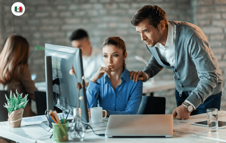 Líder acompañando a desarrolladora en proyecto de software, buen ambiente de trabajo colabora con la retención y fidelización del talento TI